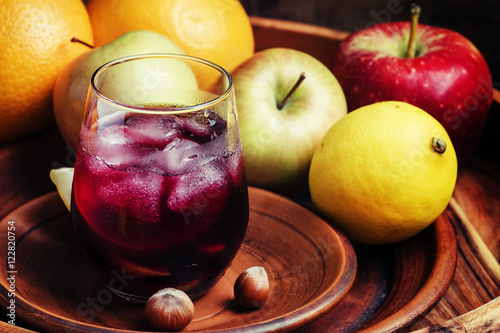 Red wine with fruit and ice on a dark wooden background, selecti