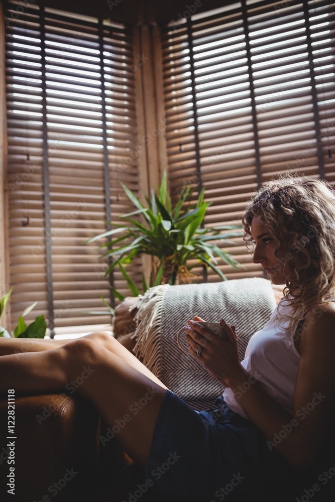 Beautiful woman having coffee in living room Beautiful woman having coffee in living room