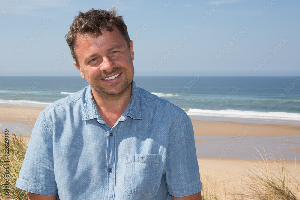 Confident man with a blue shirt onthe ocean under blue sky Confident man with a blue shirt onthe ocean under blue sky