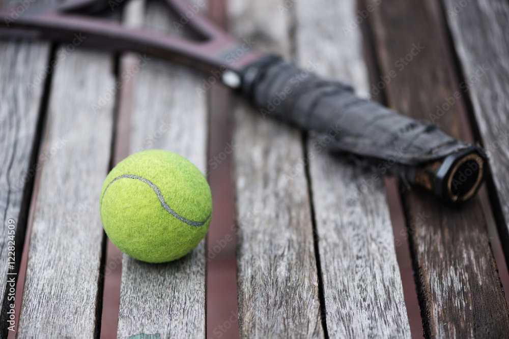 A Tennis ball and a racket at blue tennis court.