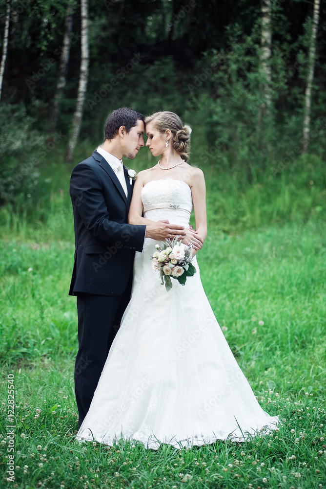 Fine art wedding. A full height picture of newlyweds in a green area, looking lovingly at each other, wedding theme Fine art wedding. A full height picture of newlyweds in a green area, looking lovingly at each other, wedding theme