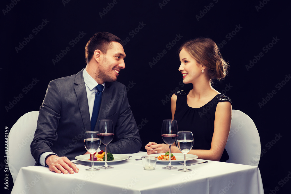 smiling couple eating main course at restaurant smiling couple eating main course at restaurant