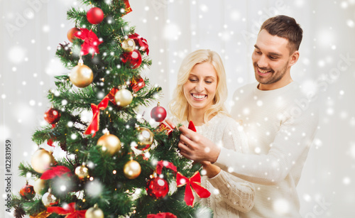 happy couple decorating christmas tree at home © Syda Productions