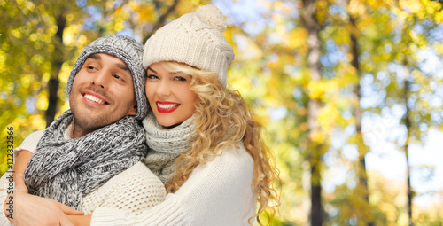 happy couple in warm clothes over autumn