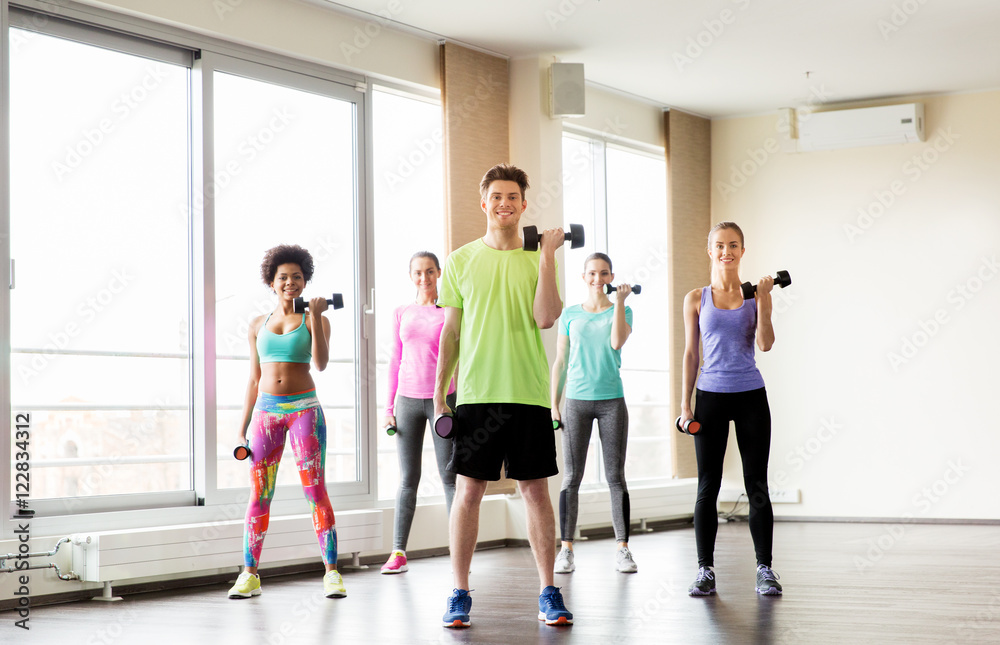 Fototapeta premium group of smiling people exercising with dumbbells