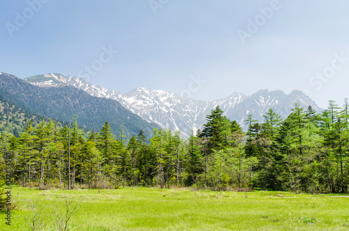 Hotaka mountain range and green field in spring at kamikochi national park nagano japan photo
