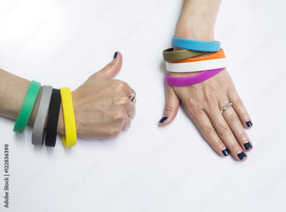Blank rubber wristbands on wrist arm. Silicone fashion round social  bracelet wear on hand. Unity band. Stock Photo