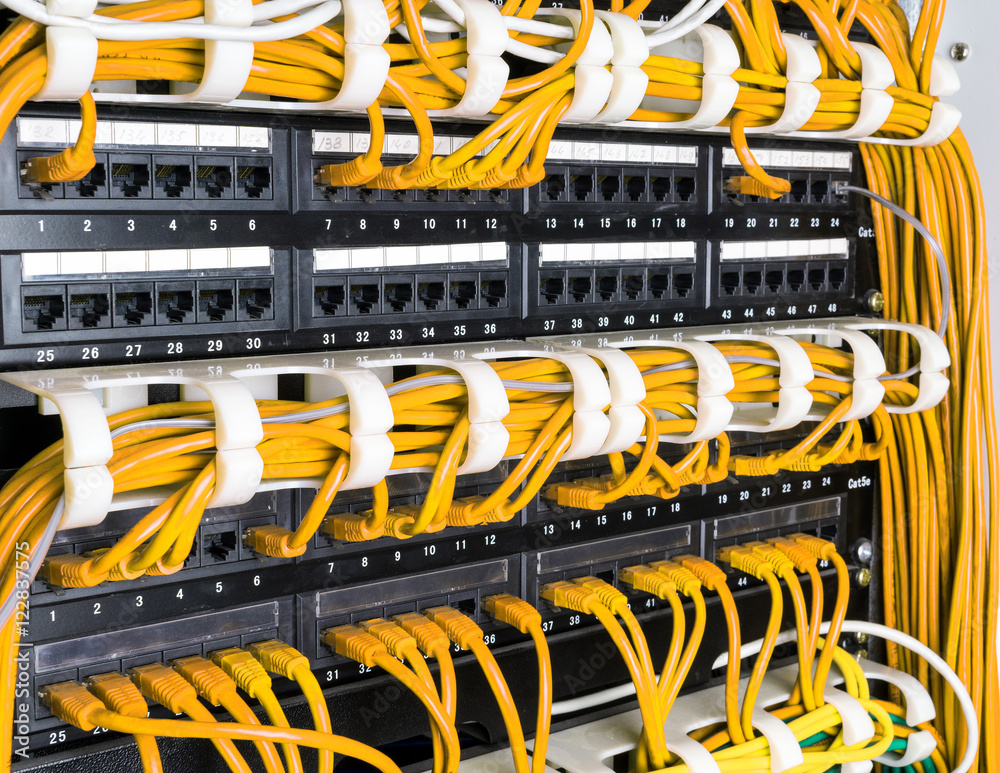 Close up of yellow network cables connected to switch