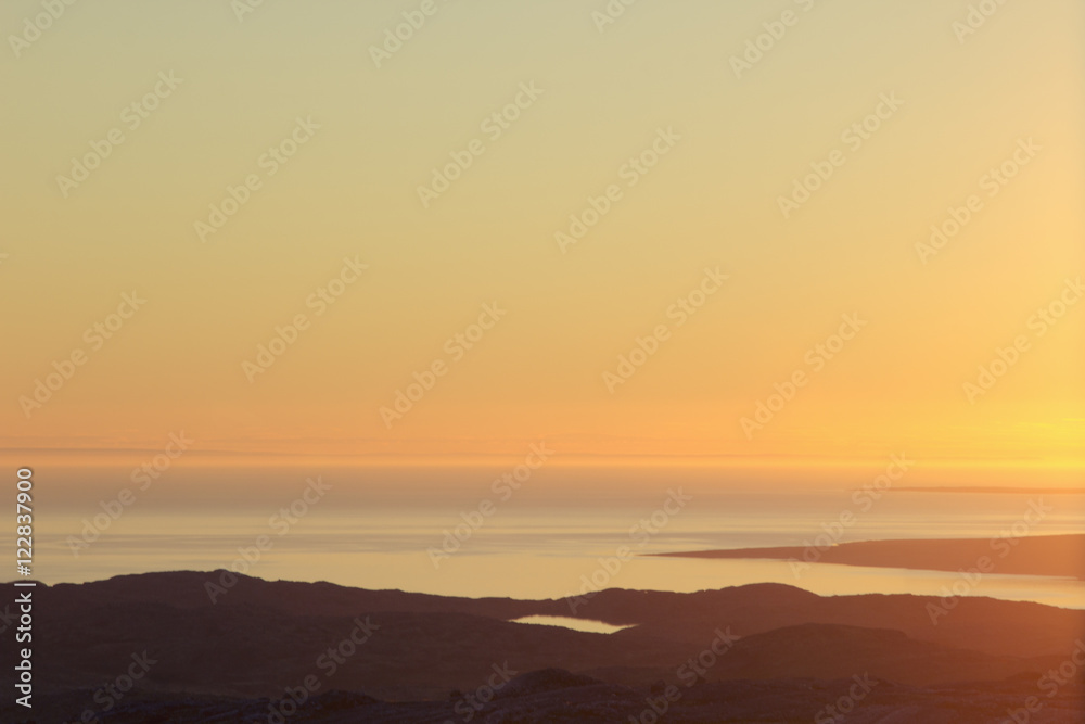 Beautiful soft sunset sky over  mountain valley and sea. Arctic summer, the tundra, Norway.