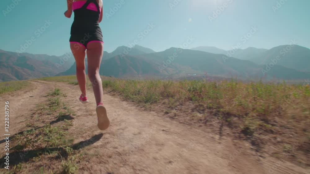 beautiful girl in sports clothes, training,running in mountainous terrain, slow motion