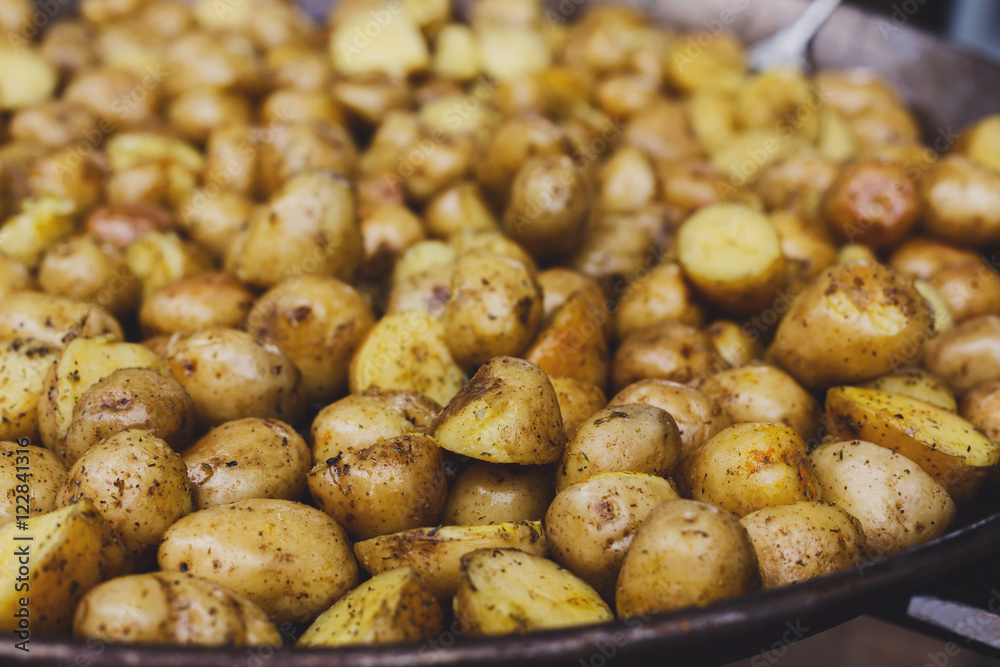 Roasted potatoes cooked in metal cauldron pot Roasted potatoes cooked in metal cauldron pot
