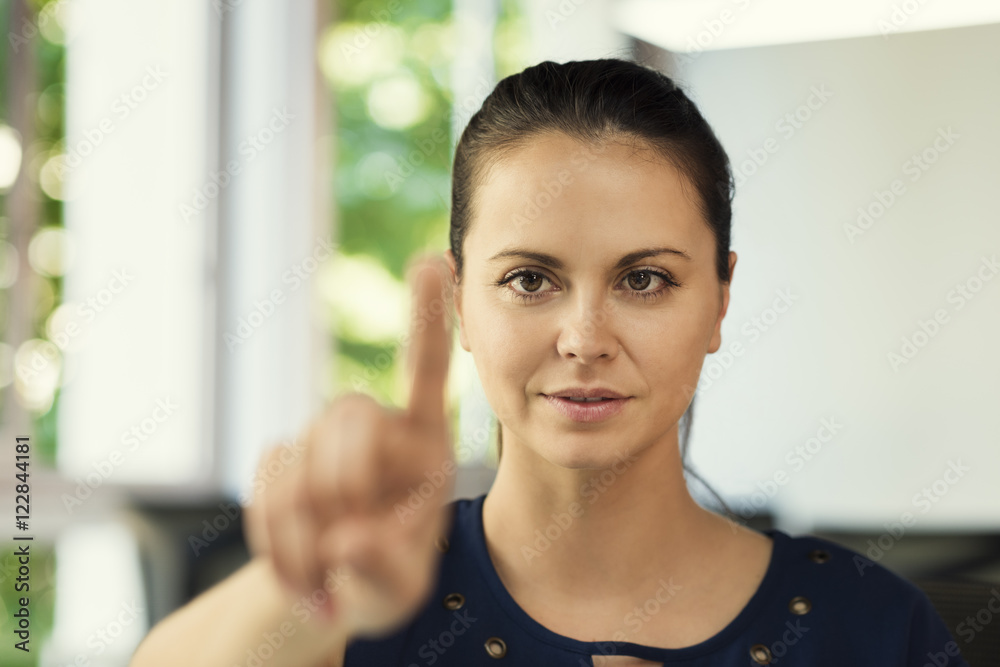 Woman finger pushing a virtual digital screen. Office background