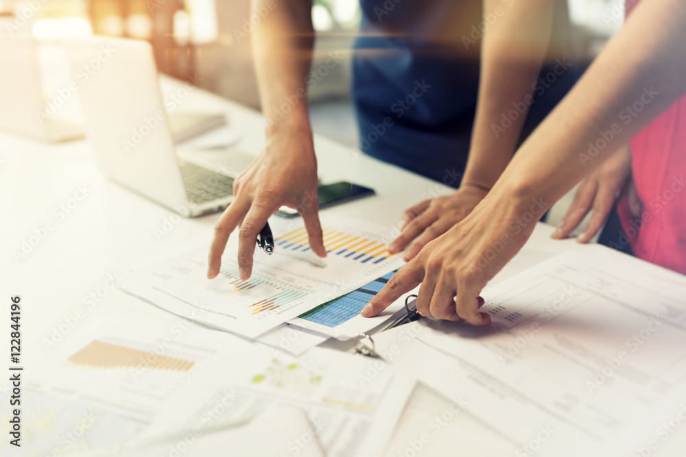 Two business women working together on graphic data paper. Two business women working together on graphic data paper.