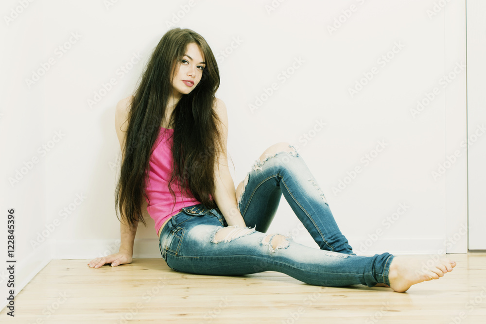 beautiful girl sitting on floor and looking at the camera