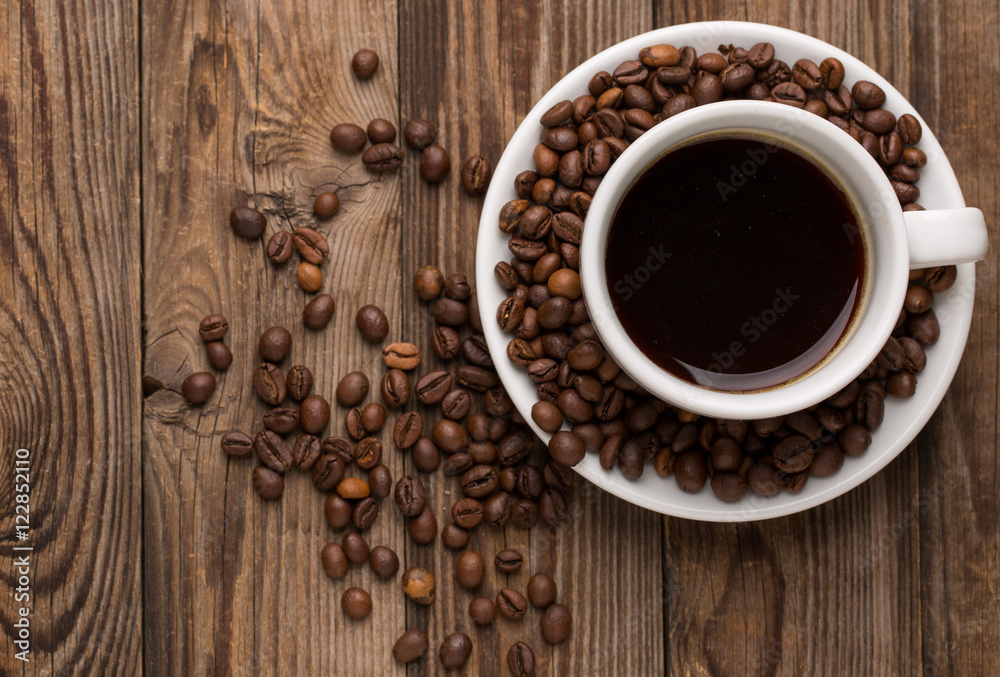 Coffee cup and coffee beans on wooden background. Coffee cup and coffee beans on wooden background.