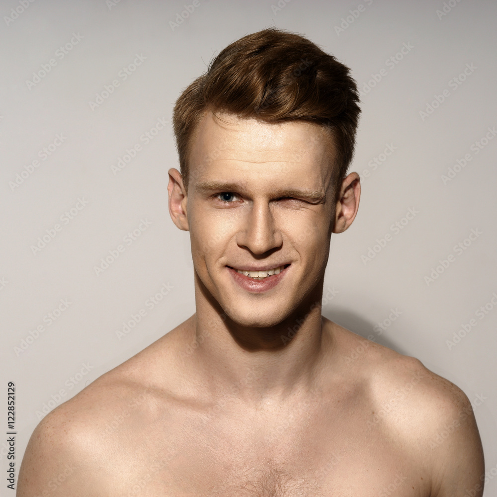 Obraz premium Fashion closeup portrait of young handsome red hair happy smiling man winking