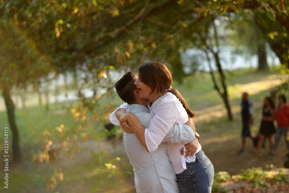 Fototapeta premium Man lifts girlfriend up in his arms