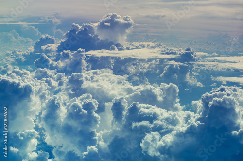 Beautiful sky with a lot of storm clouds and clouds of various forms during the flight. Aerial view through sky above the clouds abstract background.