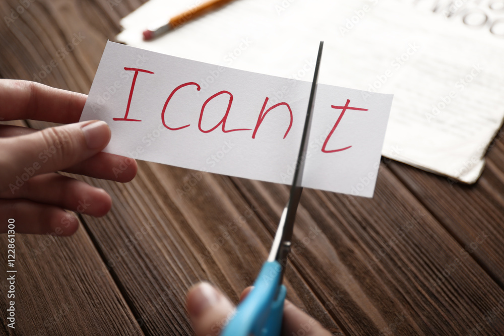 Hand cutting phrase I CAN'T on wooden background Hand cutting phrase I CAN'T on wooden background