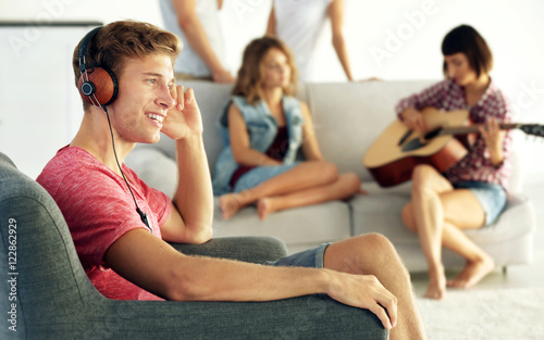 Handsome man listening to music at home