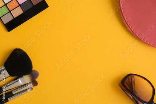 Top view of cosmetics items on yellow background