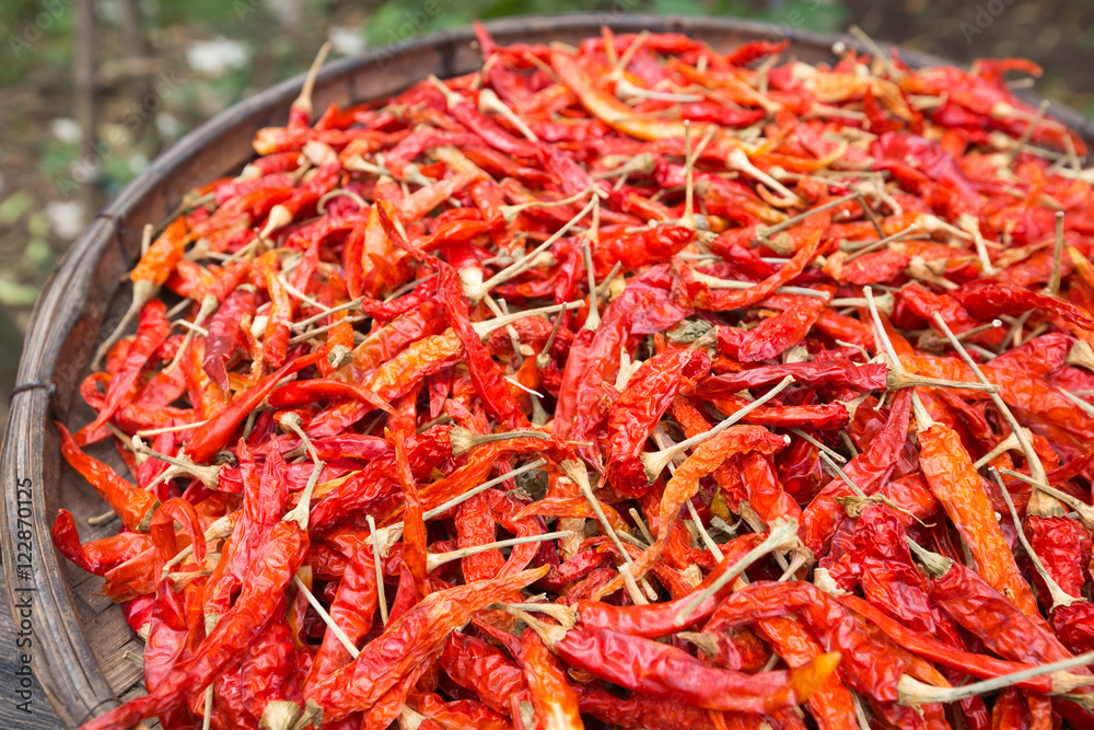 Red dried chilli on threshing basket. Dry Asian food ingredient texture. Shallow DOF, selective focus Red dried chilli on threshing basket. Dry Asian food ingredient texture. Shallow DOF, selective focus