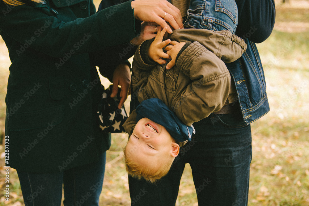 Fototapeta premium ребенок смеется на руках у родителей