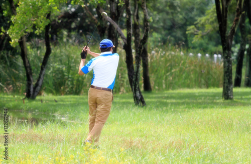 soft focus, male golfer hits golf ball from fairway
