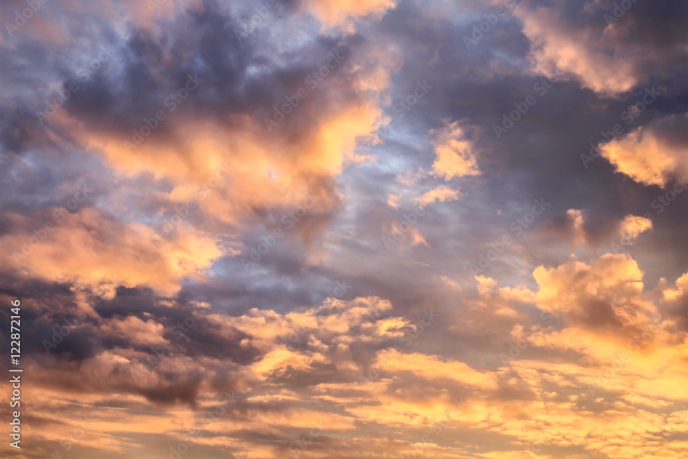 Romantic sunset sky with fluffy clouds