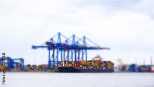 Tilt-shift panoramic view of sea port with ship  cargo  containers and lorry