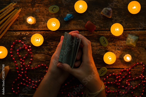fortuneteller reads fortunes by tarot cards and candles on the background of the runes