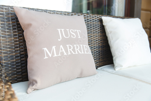 Pastel pink pillows with lettering 'Just married' lie on the bro