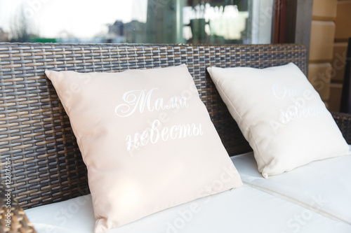 Pink pillows with lettering lie on the sofa
