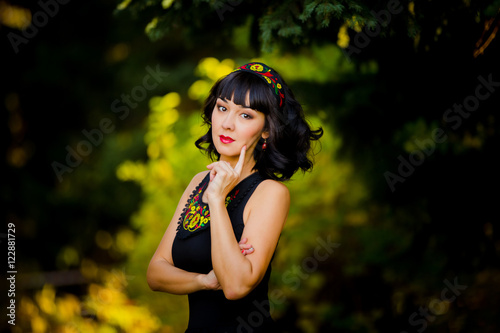Portrait of a beautiful girl in a national dress in autumn in th