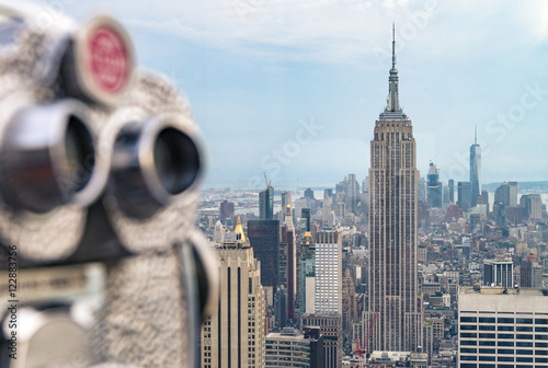 Beautiful view of downtown Manhattan from the Rockefeller Center. Binoculars with Empire State Building in the background.