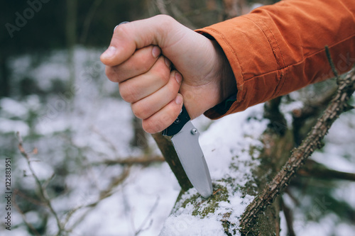 sharp pocketknife in a snowy woods in winter