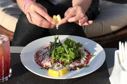 Wallpaper Mural Squeezing juice of lemon into meat carpaccio. Torontodigital.ca