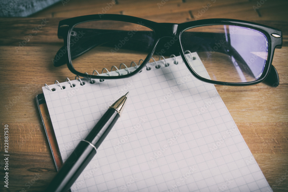 notebook pen glasses lie on a wooden background notebook pen glasses lie on a wooden background