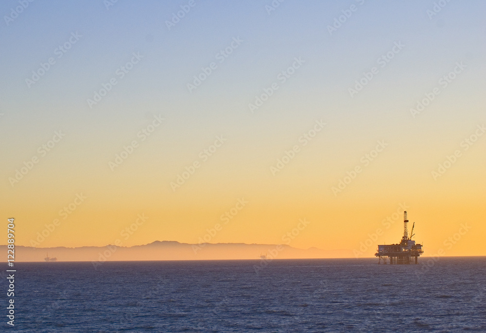 Oil Rig platform off Huntington Beach, California in Pacific ocean symbolizes global warming and environmental issues