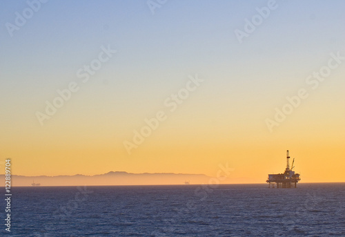 Oil Rig platform off Huntington Beach, California in Pacific ocean symbolizes global warming and environmental issues © Don