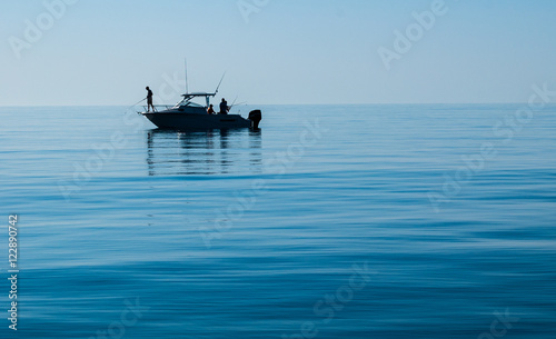 Billede på lærred Silhouette of Sport Fishing boat in calm water