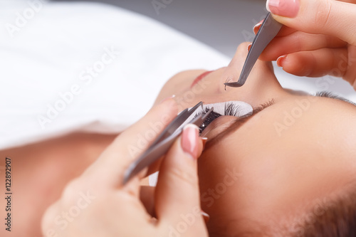 Eyelash Extension Procedure. Woman Eye with Long Eyelashes. Eyelashes with rhinestone. Lashes  close up  macro  selective focus.