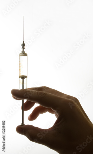 old glass syringe in hand photo