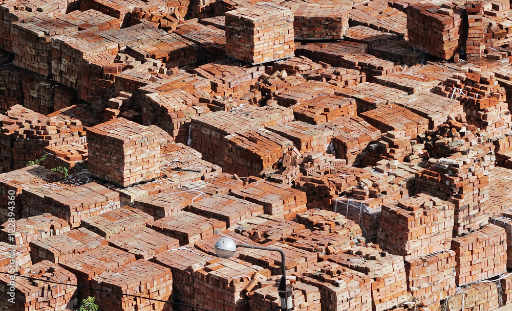a lot of red bricks on a building site. Plant for the production of bricks