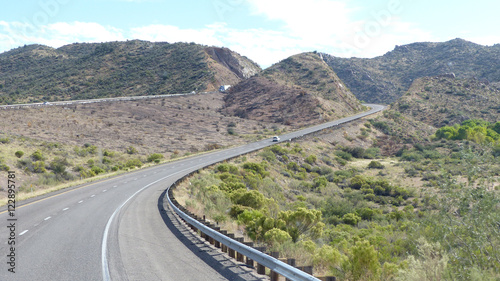Bergige Wüstenlandschaft / Kurvenreiche Autobahn durch bergige Wüstenlandschaft in Arizona, Vereinigte Staaten von Amerika, zweispurige Fahrbahn mit Markierung