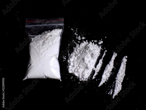 Cocaine drug powder in bag and cocaine powder pile and lines on black background