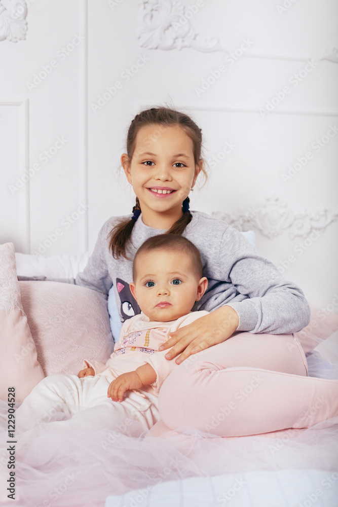 happy children, two sisters sitting on the bed. happy children, two sisters sitting on the bed.