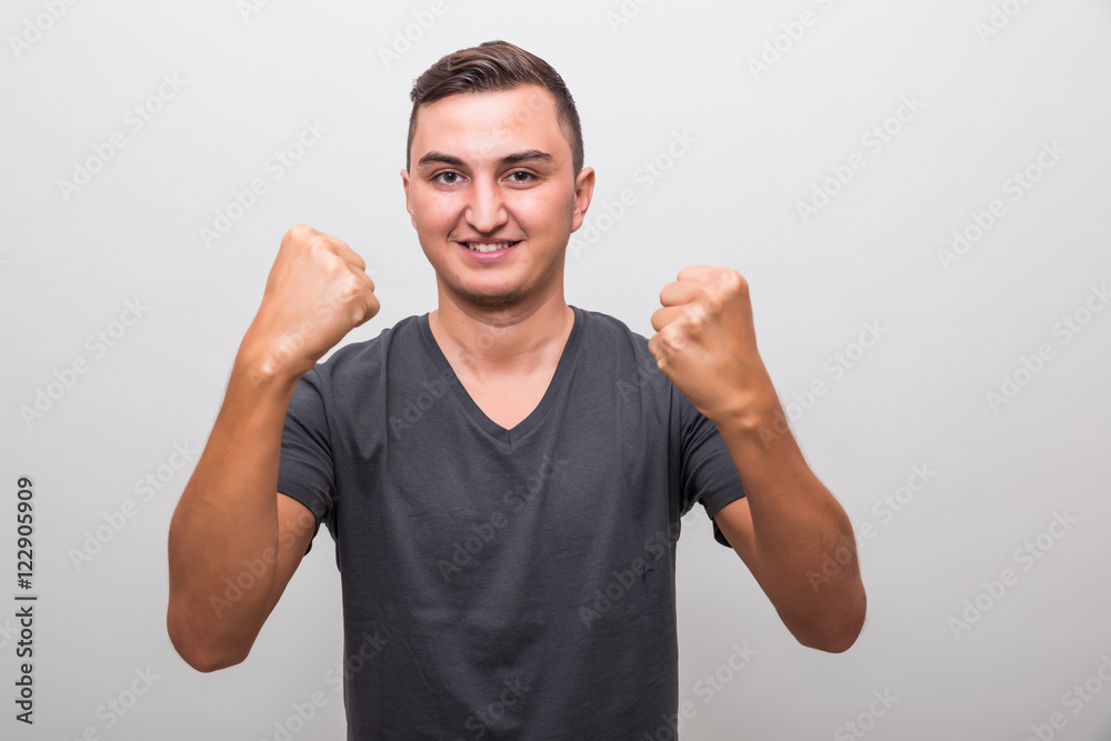 Fototapeta premium Happy excited young casual man celebrating success over grey background