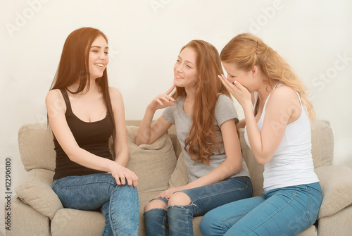 Portrait of three happy pretty young women at home