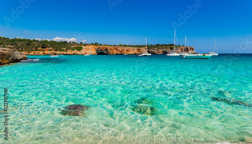 Turquoise water in the bay of Cala Varques with sailing yachts at Majorca Spain